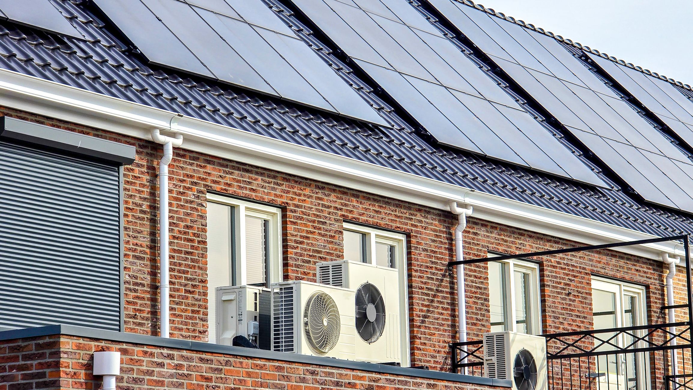 Des unités extérieures de pompes à chaleur et des panneaux solaires photovoltaïques équipent des logements.